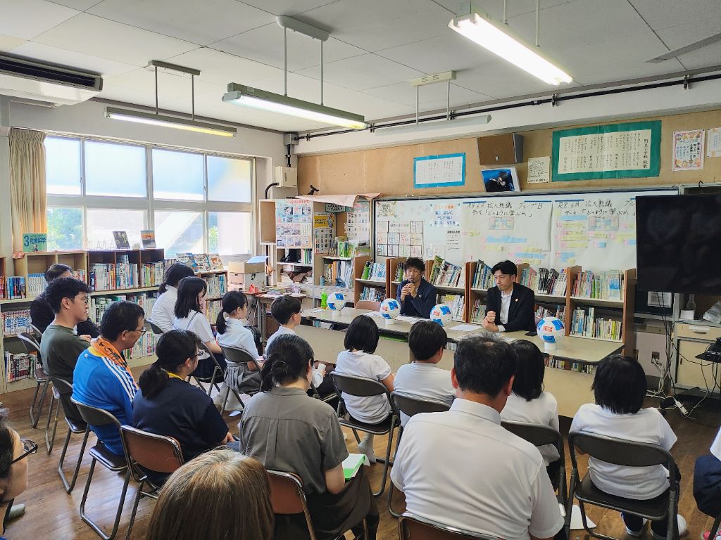 野島小中学校の体育館で熱心に子供たちへ語りかける元Jリーガー山瀬功治氏と真剣に聴く児童たち